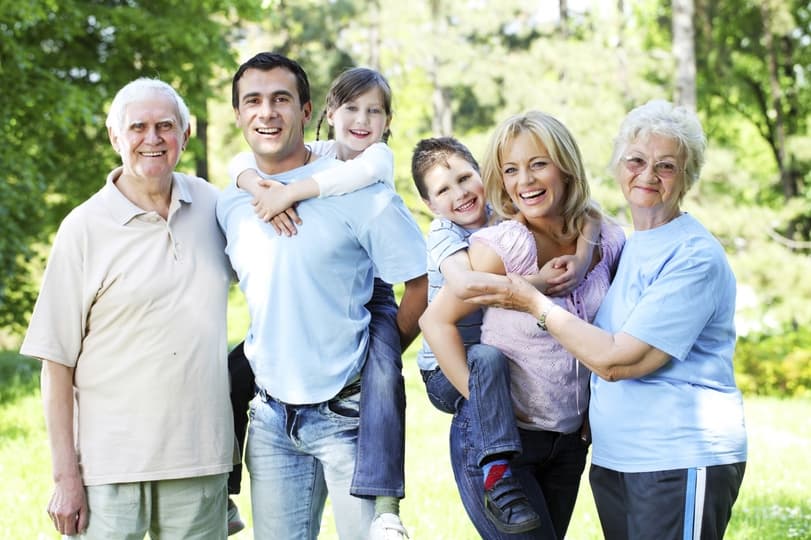 A multigenerational family standing together outdoors